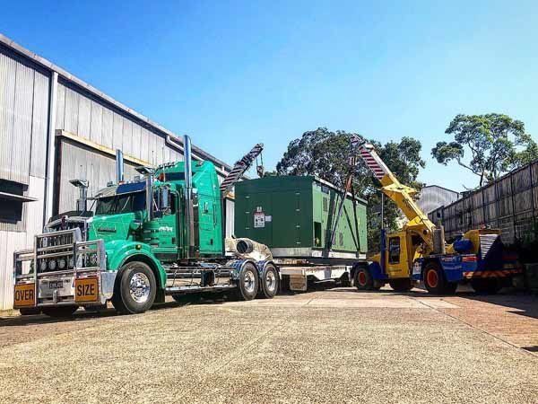 green truck hauling dumpster