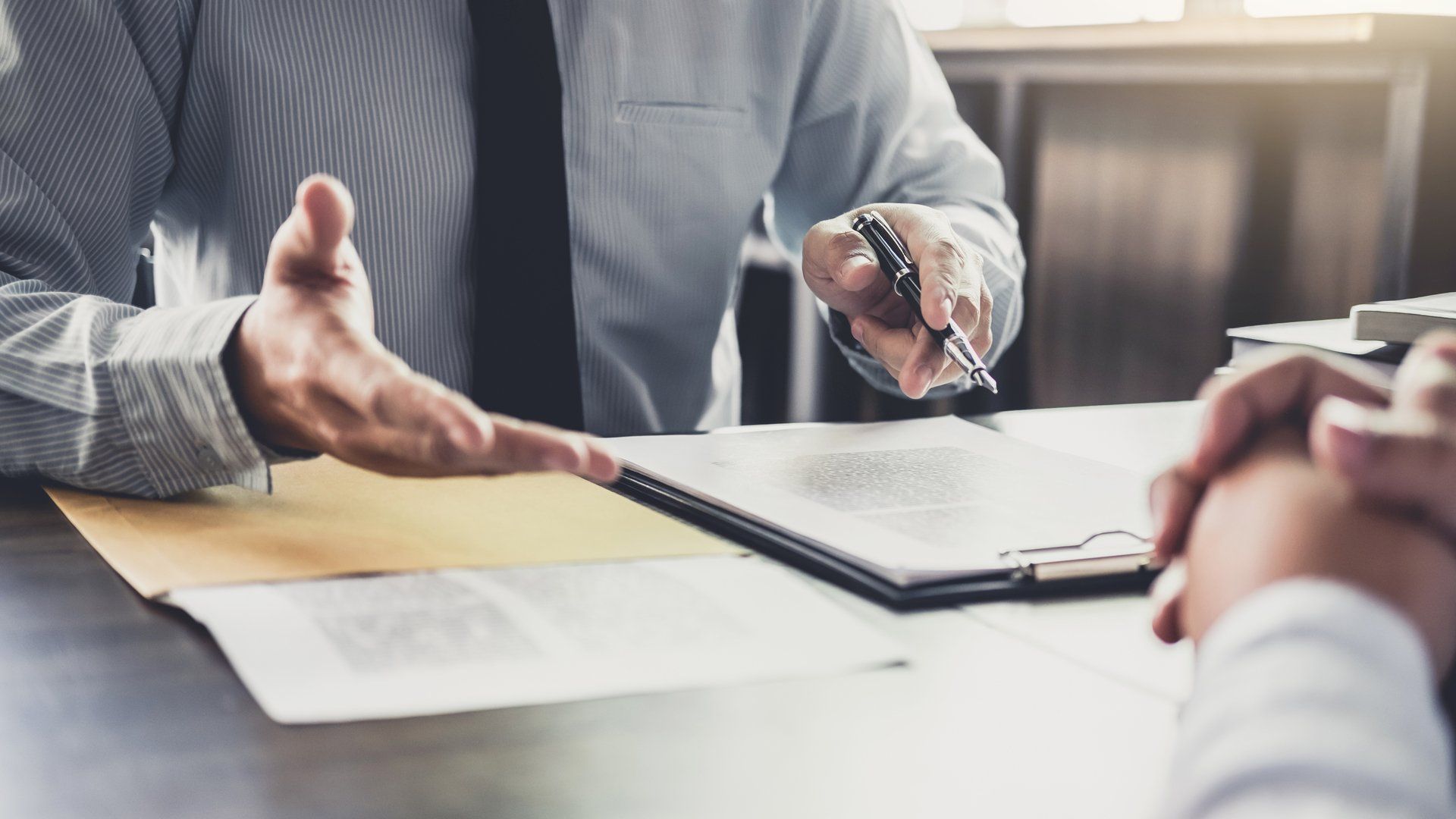 Two people talking over documents on the table