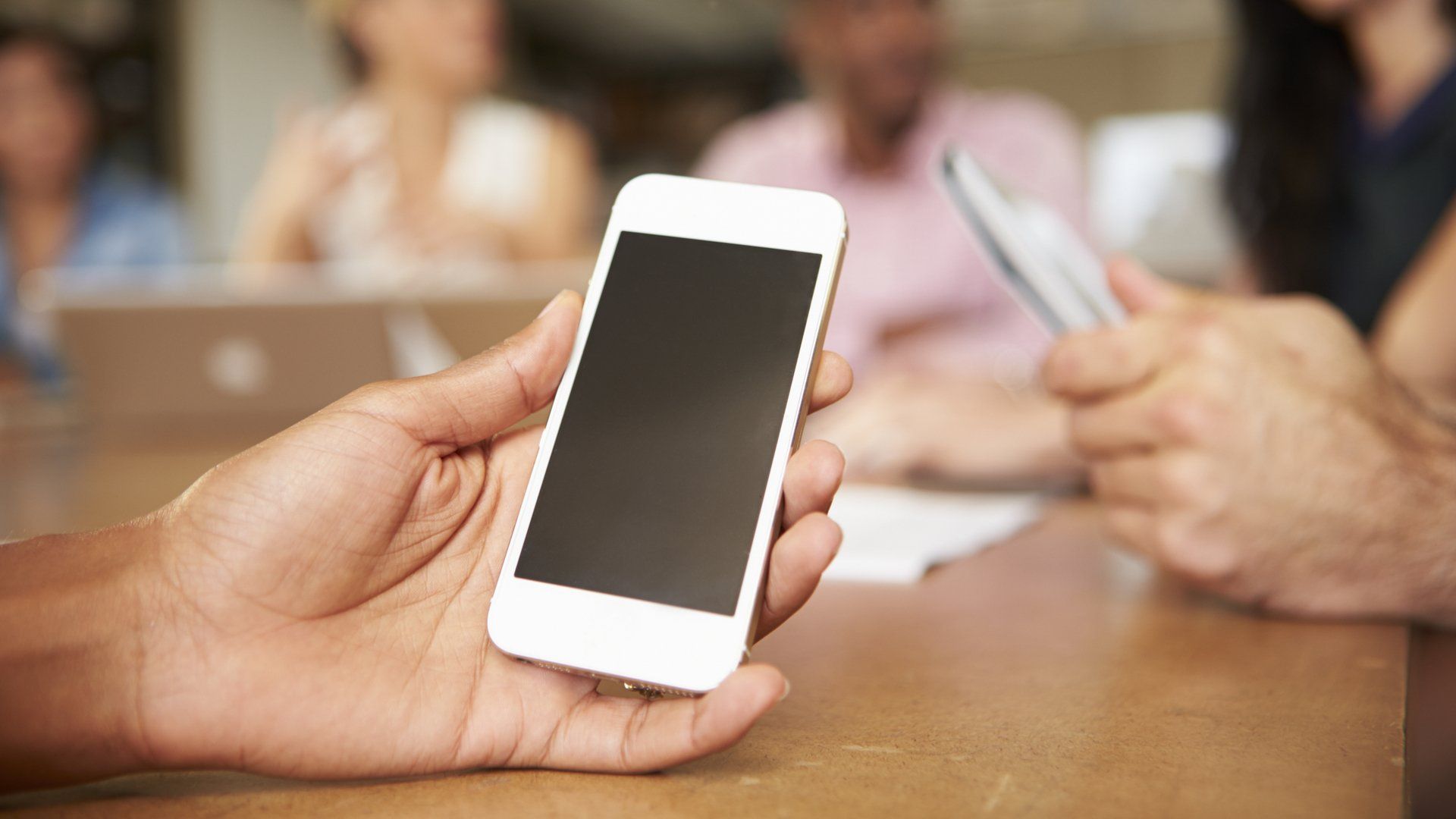 Someone holding a mobile phone in a meeting