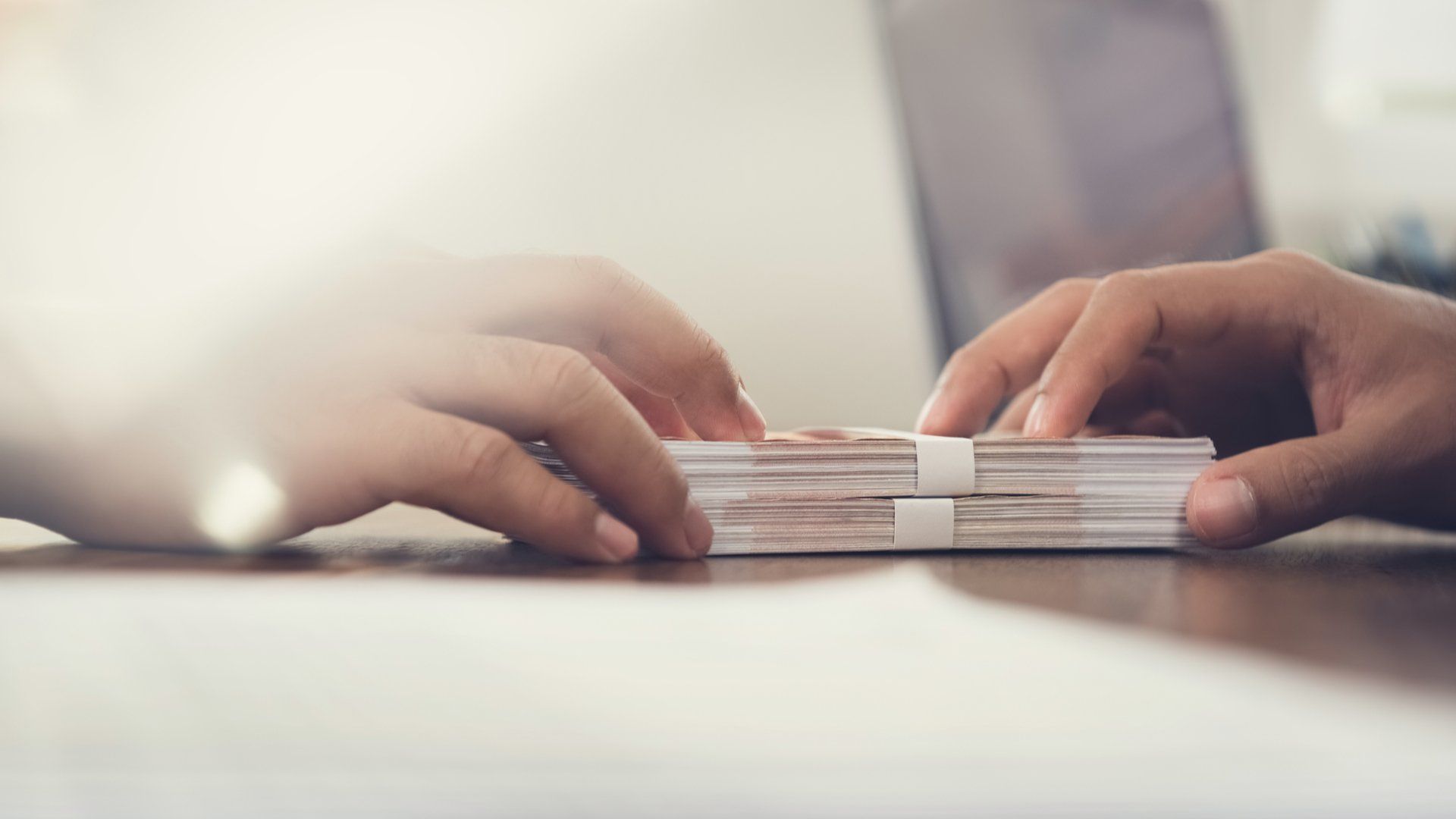 Two people passing money over a desk