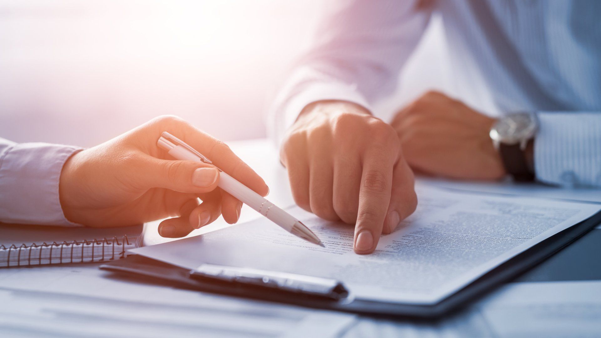Two hands pointing to a paper document