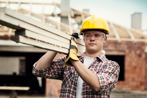 worker holding lumber on shoulder