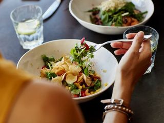 person eating a bowl of salad