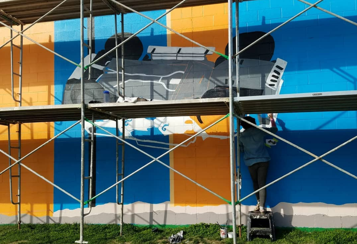Mural Artist Paints Exterior Wall Mural at Camel Express