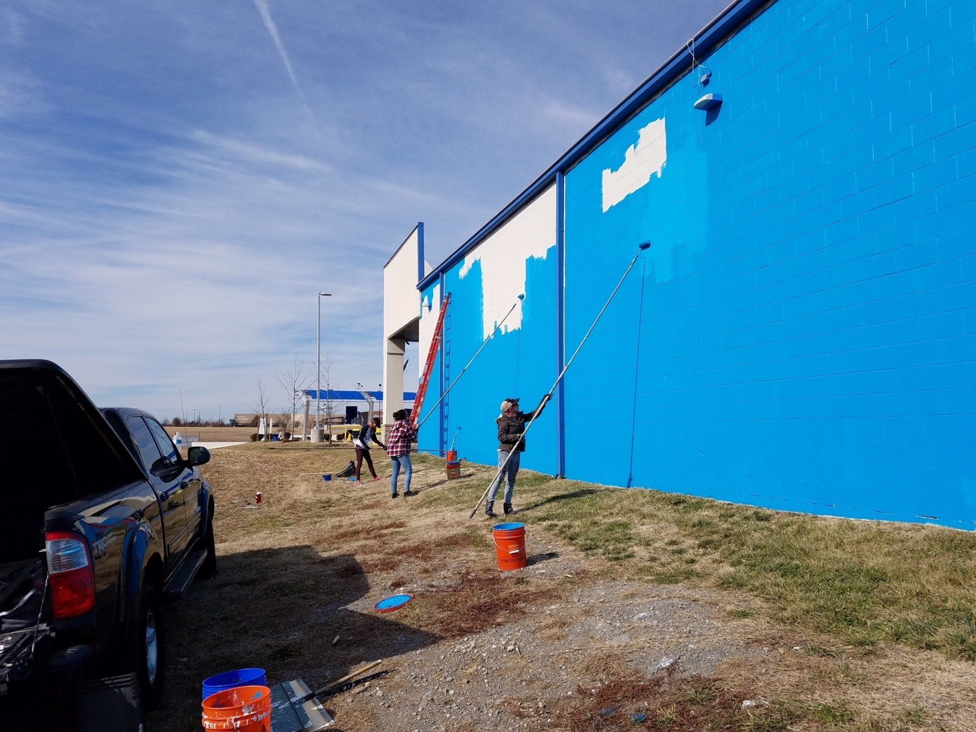Mural Artist Paints Exterior Wall Mural at Camel Express
