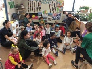 teacher sitting with class while teaching
