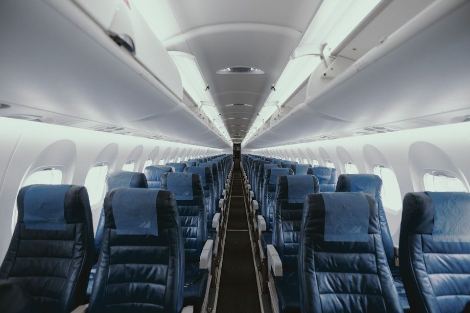 Inside a plane with empty seats / white & blue & grey / Perfect Irish Trip / Sustainable & eco-friendly travel tips