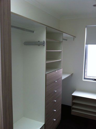 walk in wardrobe with brown wood coloured facia