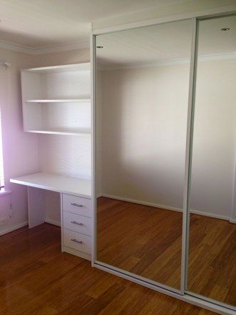white frame sliding mirrored wardrobe with desk and shelving