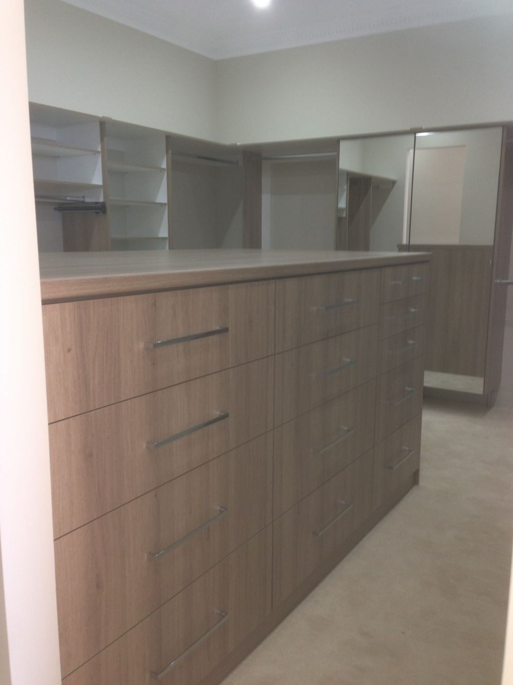 walk in wardrobe with dresser in the middle of room