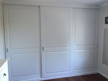 white paneled sliding wardrobe with silver handles