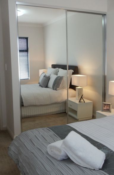 mirrored 2 panel sliding wardrobe reflecting white bed