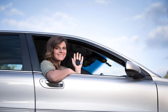 lady in car smiling with keys in hand