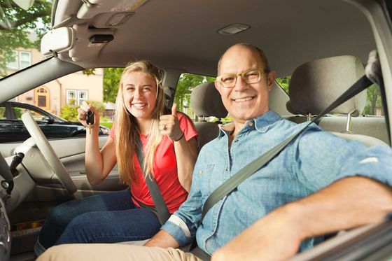 man and girl in car smiling
