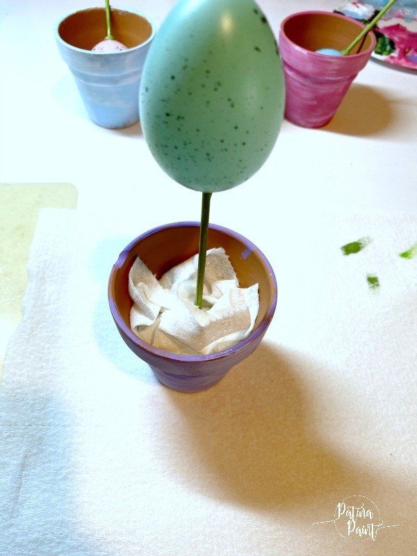 Easter egg on a skewer in a terra cotta pot