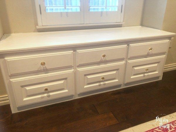white window seat with drawers and glass pulls