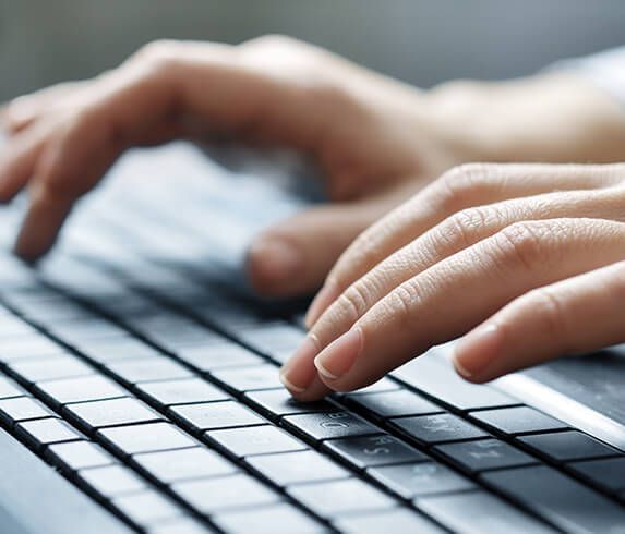 person typing on a laptop keyboard