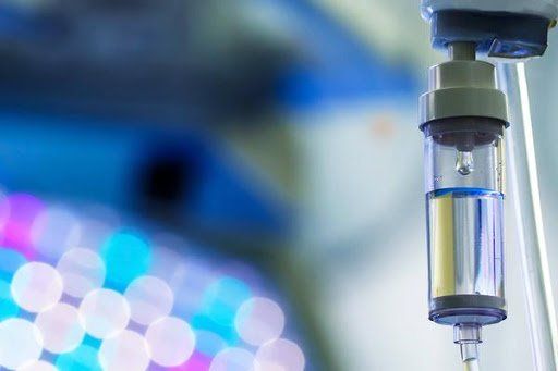 IV drip cartridge with blurred lights in the background