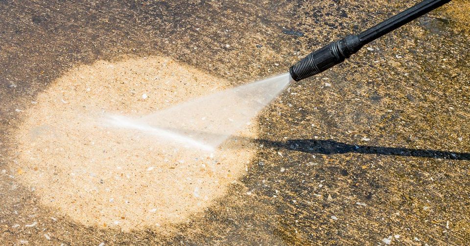 Pressure cleaning concrete to remove grime and mould. 