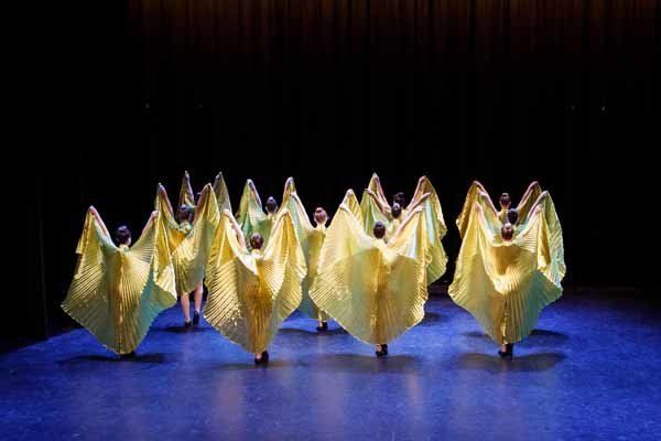 dancers in gold dresses kicking