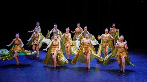 group of dancers in gold dresses