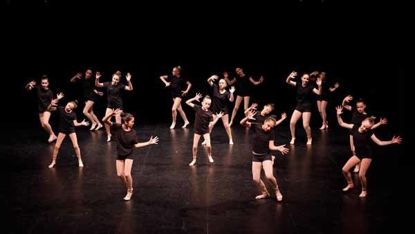 dance group wearing black on stage