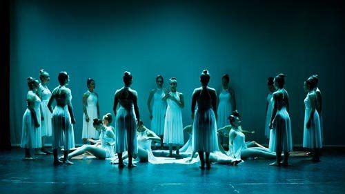 dancers on blue stage with white dress