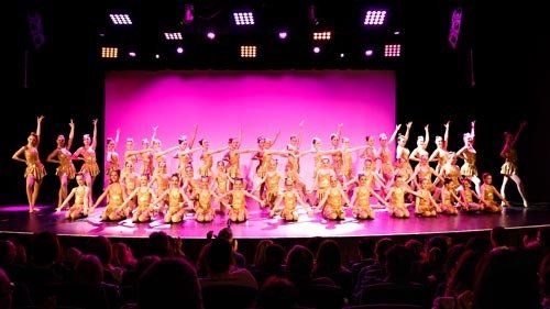many dancers on stage performing