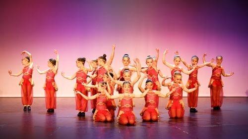 dancers on stage in red costumes