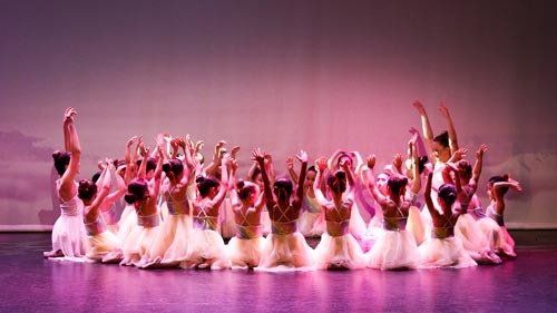 dancers on stage in white dresses
