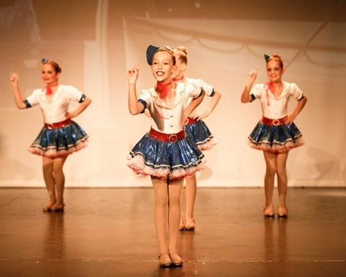 dancers on stage in blue skirts