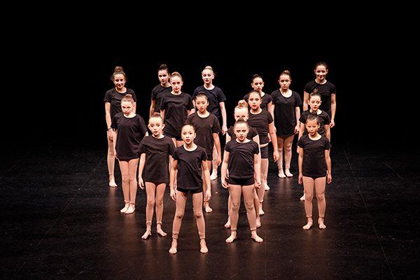 dance group on stage wearing black