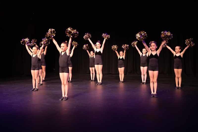 group of dancers holding up objects