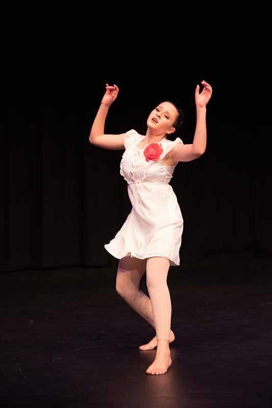 young woman in white dress dancing