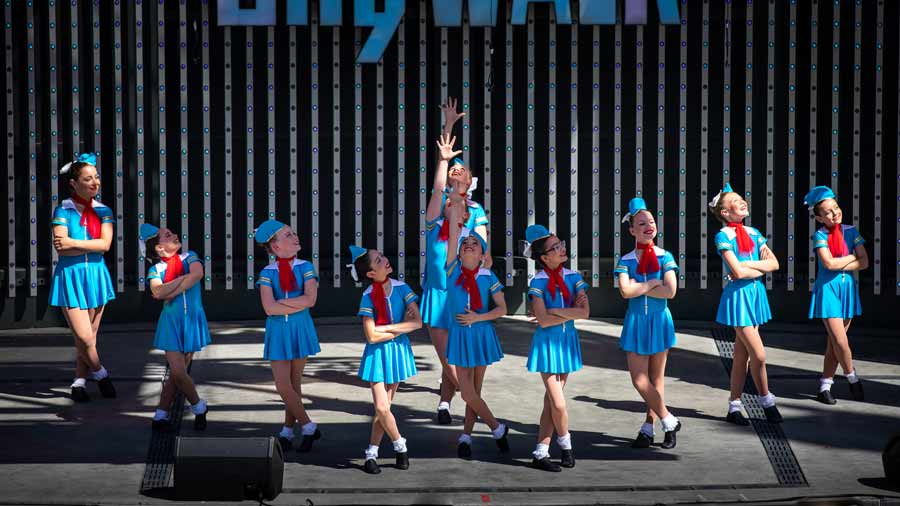 small dance group performing on stage in blue