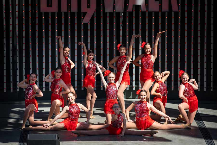 dance group performing on stage in red