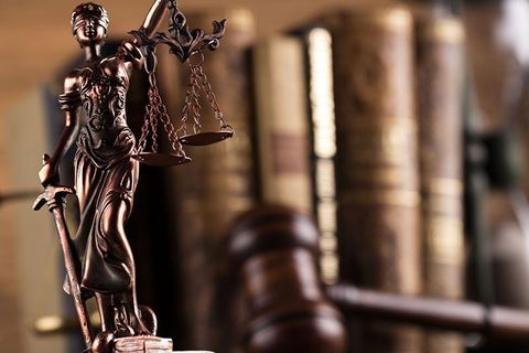 una statuetta con in mano una bilancia a due piatti