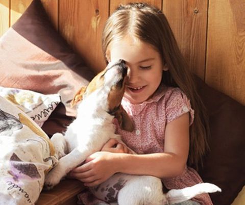 bambina gioca con un cane